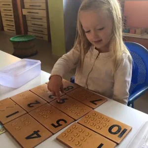 young-child-working-with-montessori-number-dot-boards-math